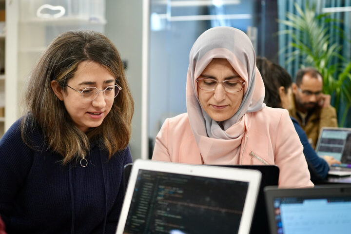 A volunteer and a Trainee coding together