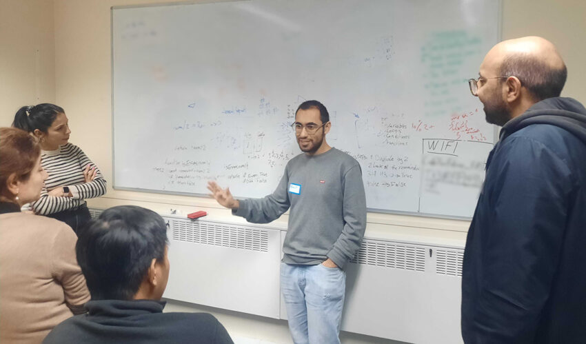 Photo of Amirreza (centre) describing a topic to a group of trainees.