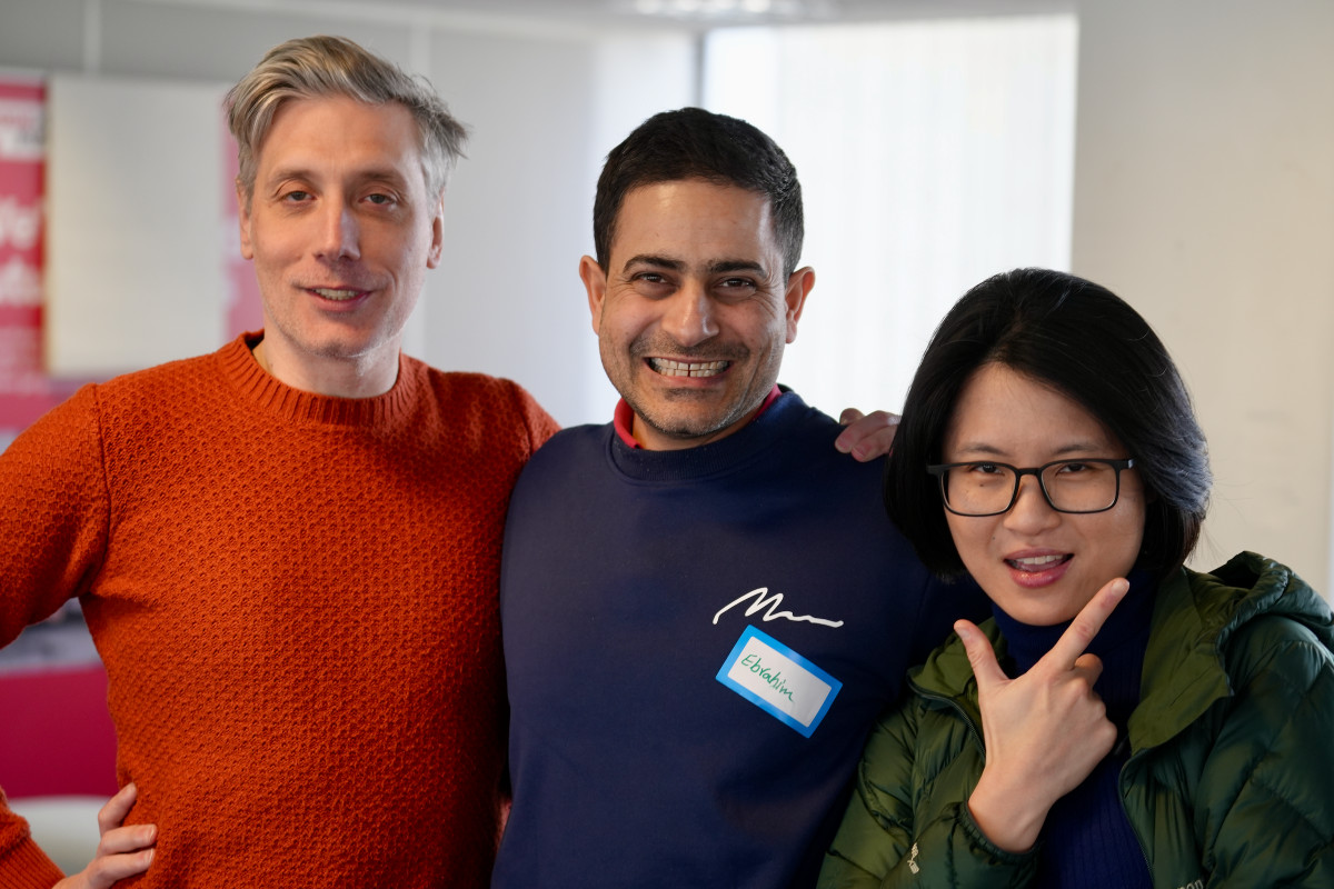 Three people posing together indoors.